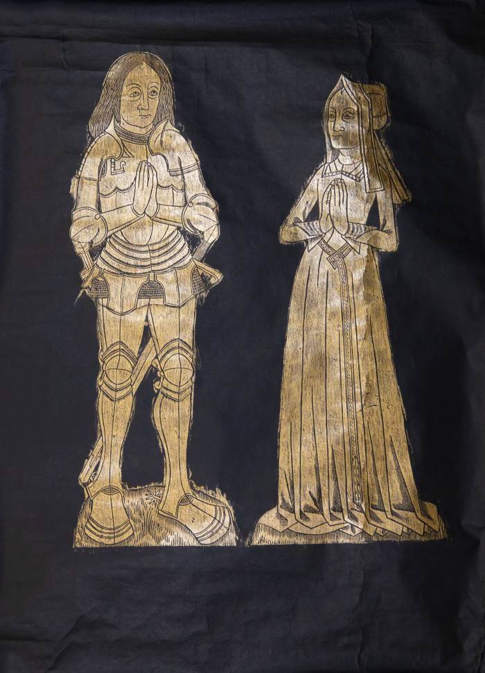 Paper and heelball; gold wax on black paper rubbing of 15th century British monumental brass. On the left is a man wearing armor, he has shoulder length hair and hands clasped in prayer. His wife is on the right in a long gown with a long belt and fur accents on her collar and cuffs.